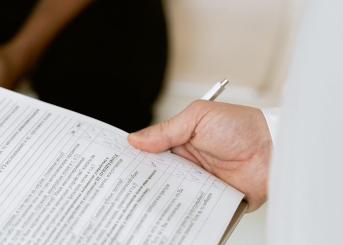 A healthcare professional reviewing a patient's medical chart during a consultation.